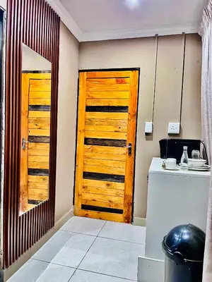 a kitchen with a wooden door and a counter at Executive Galaxy Guest House Nkowankowa in Nkowakowa