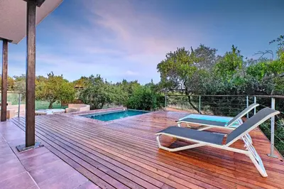 a deck with a lounge chair and a swimming pool at Shasha Lodge, Mabalingwe Game Reserve in Mabula