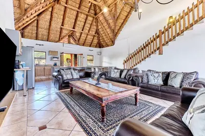 a living room with leather furniture and a table at Shasha Lodge, Mabalingwe Game Reserve in Mabula