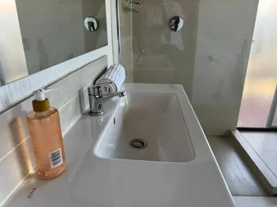 a white bathroom sink with a soap bottle on it at Shasha Lodge, Mabalingwe Game Reserve in Mabula