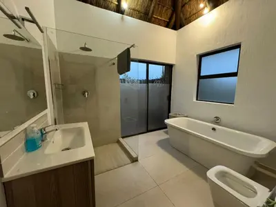 a bathroom with a tub and a sink and a toilet at Shasha Lodge, Mabalingwe Game Reserve in Mabula