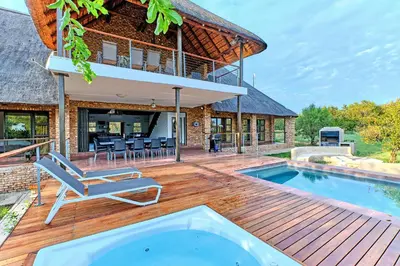 an outdoor deck with a pool and a house at Shasha Lodge, Mabalingwe Game Reserve in Mabula