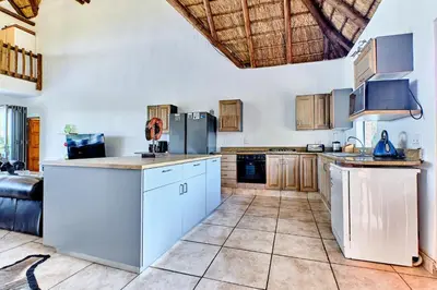 a large kitchen with white cabinets and appliances at Shasha Lodge, Mabalingwe Game Reserve in Mabula