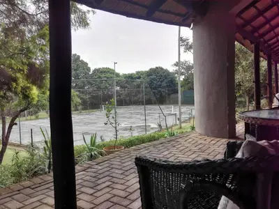 a patio with a view of a tennis court at The Homestay in Nelspruit
