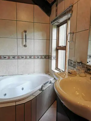 a bathroom with a tub and a sink at The Homestay in Nelspruit