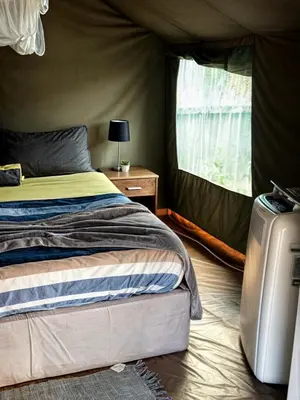 a bedroom with a bed in a tent at Kruger Yebo Safari Tents-Stay Inside Kruger in Skukuza