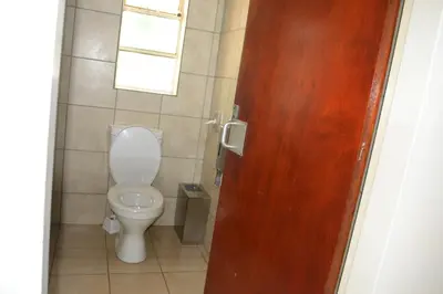 a bathroom with a toilet and a wooden door at Kruger Yebo Safari Tents-Stay Inside Kruger in Skukuza