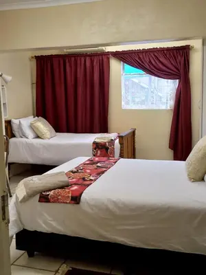 a hotel room with two beds and a window at Beit-El BnB in Polokwane