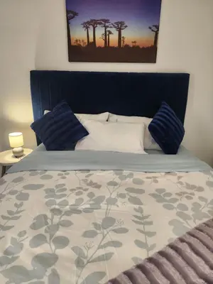 a bedroom with a bed with blue pillows at Faerie Glen Heights in Pretoria