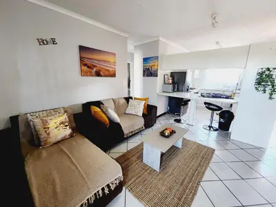 a living room with a couch and a table at Faerie Glen Heights in Pretoria
