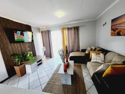 a living room with a couch and a table at Faerie Glen Heights in Pretoria