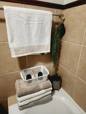 a bathroom with towels and a basket on the sink at Faerie Glen Heights in Pretoria