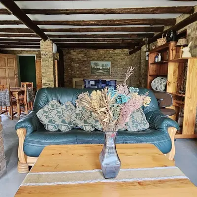 a green couch with a vase on a coffee table at Villa Dachie in Rayton