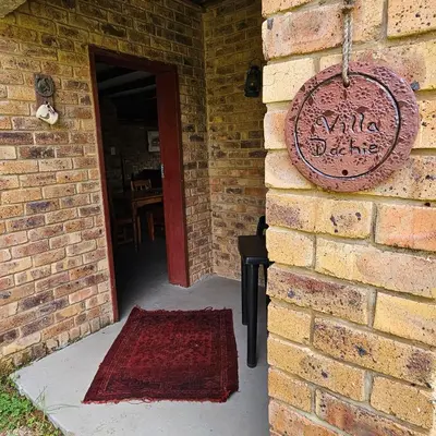 a brick wall with a sign on the side of a building at Villa Dachie in Rayton