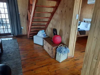 a room with a bed and a red ball on a wooden floor at Habibi Holiday Home in Marloth Park