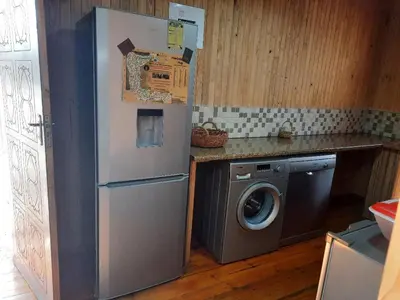 a kitchen with a refrigerator and a washing machine at Habibi Holiday Home in Marloth Park