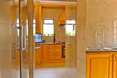 a kitchen with wooden cabinets and a sink at Villa Toledo - Luxurious Mediterranean styled home in Pretoria