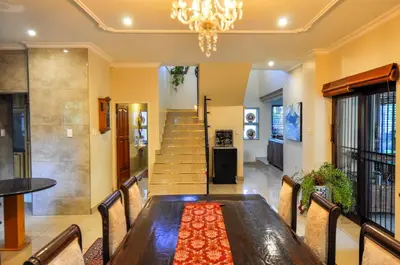 a dining room with a long table and a chandelier at Villa Toledo - Luxurious Mediterranean styled home in Pretoria