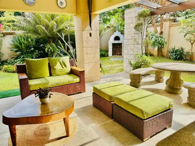 an outdoor patio with a couch and a table at Villa Toledo - Luxurious Mediterranean styled home in Pretoria