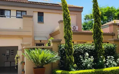a house with trees and plants in front of it at Villa Toledo - Luxurious Mediterranean styled home in Pretoria