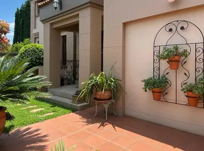 a house with potted plants on the side of it at Villa Toledo - Luxurious Mediterranean styled home in Pretoria