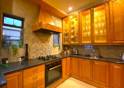 a kitchen with wooden cabinets and a stove top oven at Villa Toledo - Luxurious Mediterranean styled home in Pretoria