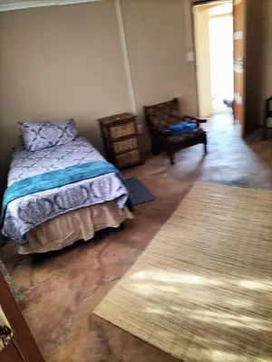 a bedroom with a bed and a wooden floor at BLESSINGS Sleep Over in Mokopane