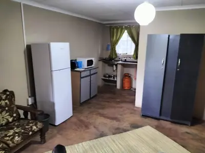 a kitchen with a refrigerator and a table and a couch at BLESSINGS Sleep Over in Mokopane