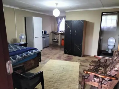 a room with a bedroom with a bed and a kitchen at BLESSINGS Sleep Over in Mokopane