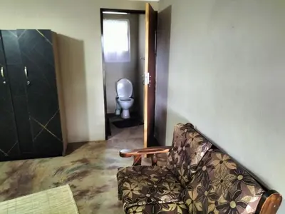 a living room with a chair and a toilet at BLESSINGS Sleep Over in Mokopane
