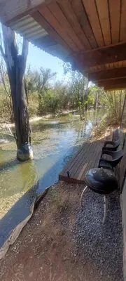 two chairs sitting on a wooden deck next to a river at Vulture's View 9 in Hartbeespoort