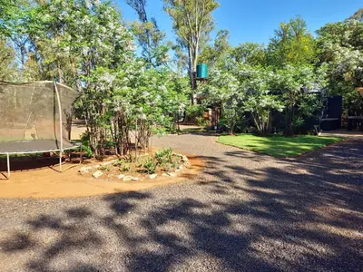 a garden with a tent and trees and grass at Vulture's View 9 in Hartbeespoort