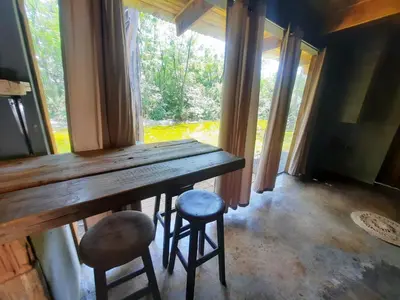 a table and two stools in a room with a window at Vulture's View 9 in Hartbeespoort