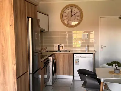 a kitchen with a sink and a clock on the wall at The Blyde Crystal Lagoon Luxurious Apartment in Pretoria
