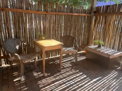 a wooden table and chairs on a patio at Panache Wildlife Cottage-Self Catering in Hoedspruit