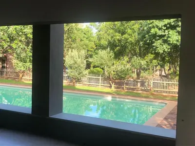 a view of a swimming pool through a window at Panache Wildlife Cottage-Self Catering in Hoedspruit
