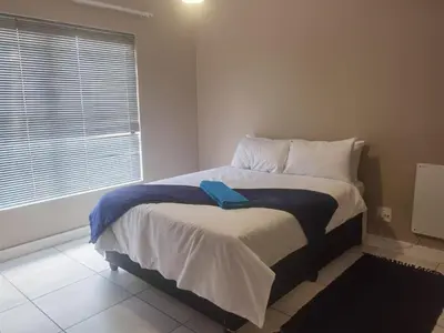 a bedroom with a bed with a blue towel on it at Three Bedroom Apartment At The Blyde in Boschkop