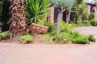a sign sitting on the side of a street at Perfectly located beauty in secure Estate in Sandton