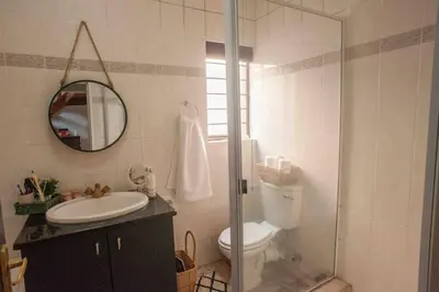 a bathroom with a toilet and a sink and a mirror at Perfectly located beauty in secure Estate in Sandton