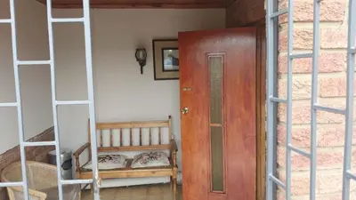 a room with a wooden door and a ladder at Jay's Guest House in Witbank