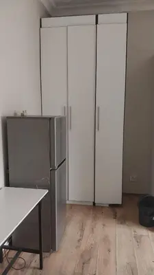 a kitchen with two white cabinets and a refrigerator at Jay's Guest House in Witbank