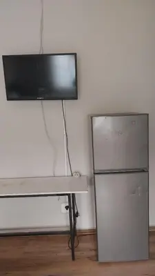 a television on top of a desk next to a refrigerator at Jay's Guest House in Witbank