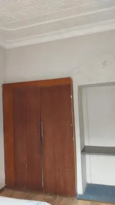 a wooden cabinet in a room with a wall at Jay's Guest House in Witbank