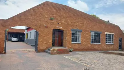 a red brick building with a red door at Jay's Guest House in Witbank