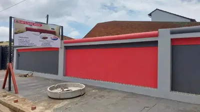 a building with a red garage door and a dog bowl at Jay's Guest House in Witbank