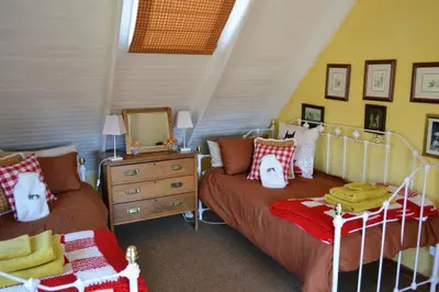 a bedroom with two beds and a mirror at Dullies Cottage in Dullstroom