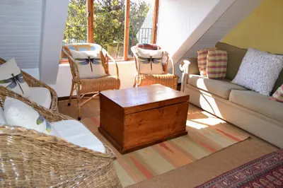 a living room with a couch and two chairs at Dullies Cottage in Dullstroom