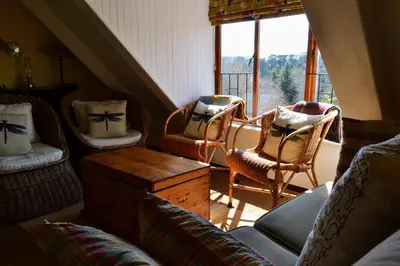 a living room with chairs and a window at Dullies Cottage in Dullstroom