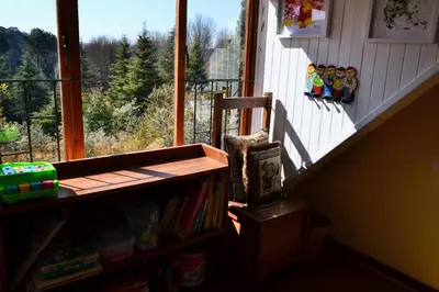 a room with a book shelf next to a window at Dullies Cottage in Dullstroom