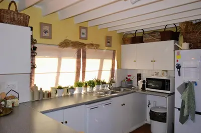 a kitchen with white cabinets and a counter top at Dullies Cottage in Dullstroom